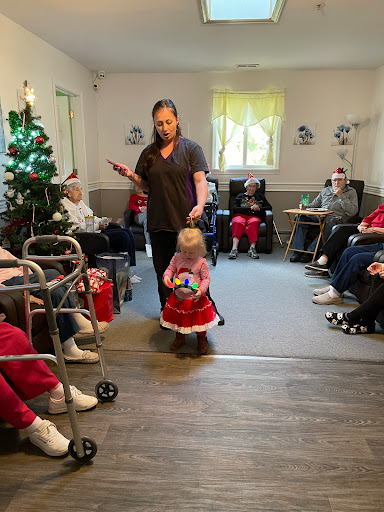 A joyful interaction during a holiday performance at a care home, bringing smiles to both the elderly residents and young children.