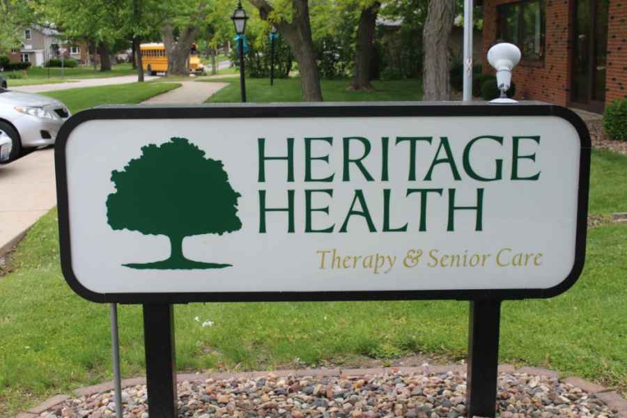 A sign for Heritage Health, indicating therapy and senior care services, featuring a tree logo.