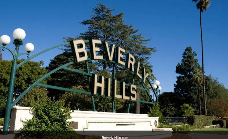 Iconic Beverly Hills sign surrounded by greenery.
