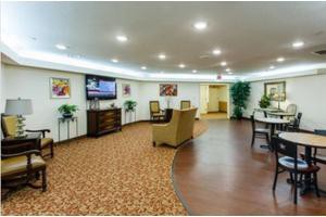 A modern lobby area featuring comfortable seating and a large television.