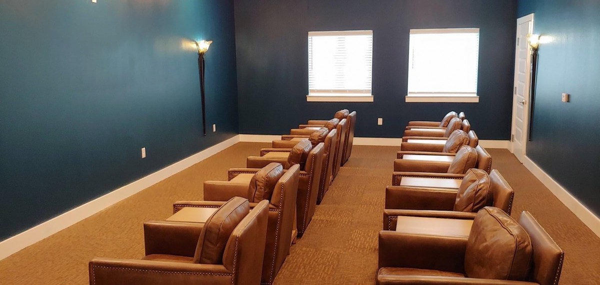 A cozy home theater room with leather armchairs and soft lighting.