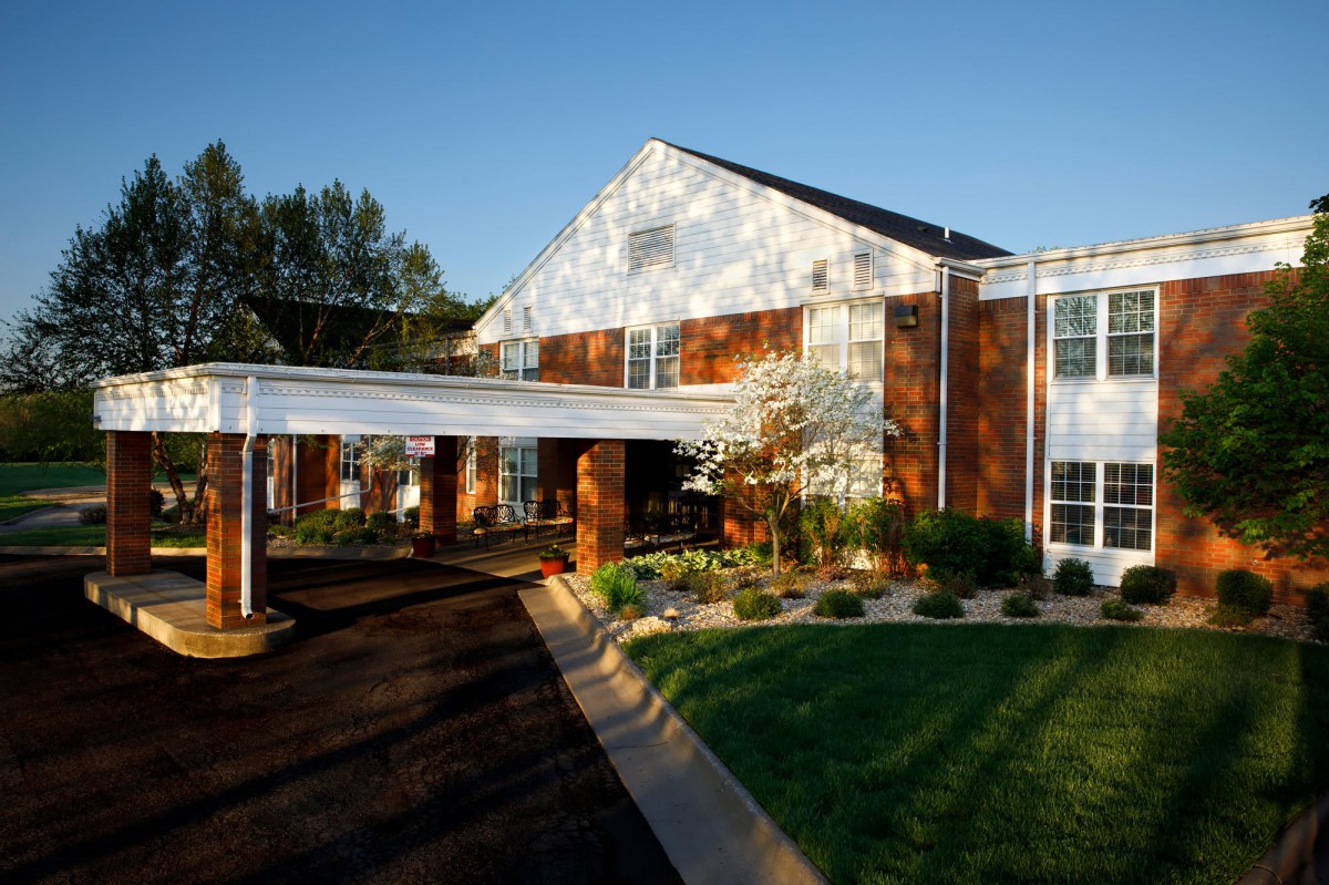 Exterior view of a building with a landscaped lawn and trees.