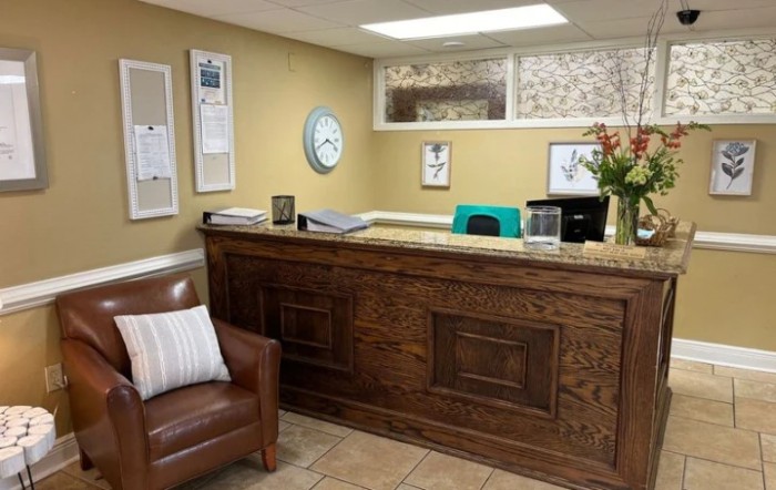 A cozy reception area with a wooden desk and comfortable seating.