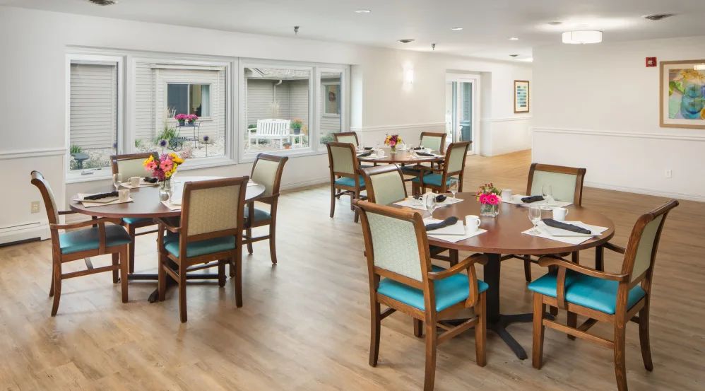 A well-lit dining area with multiple tables set for meals.