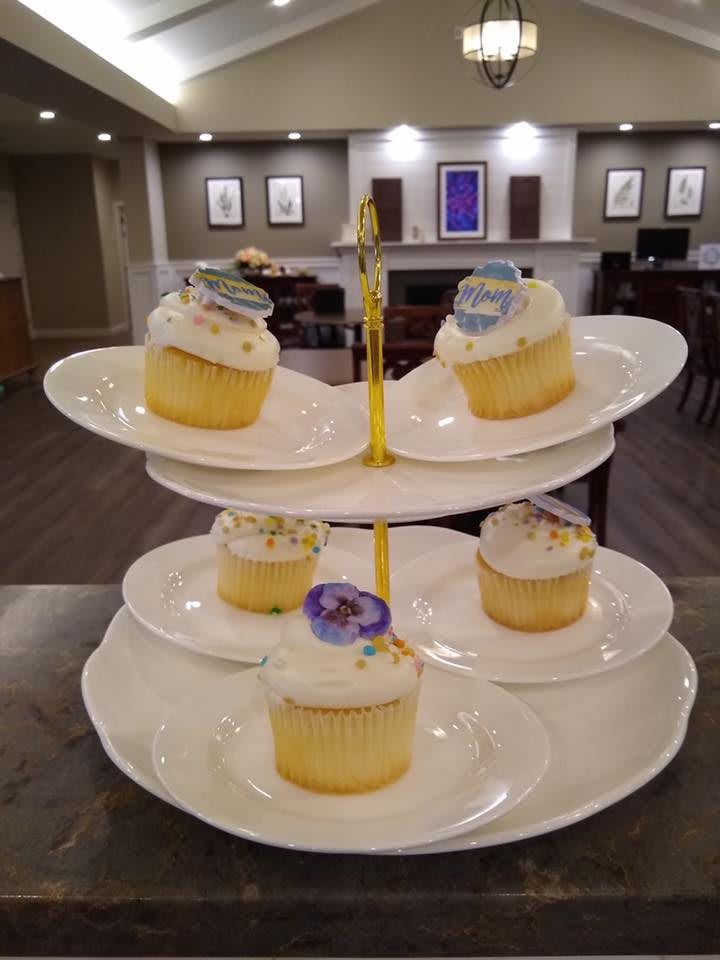 A display of decorated cupcakes on a three-tiered stand.