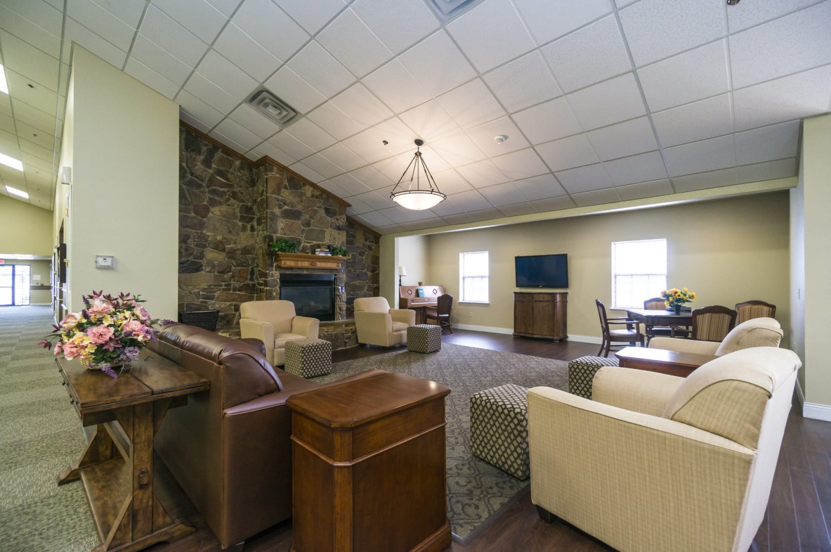 A spacious living room features comfortable seating, a fireplace, and a television.