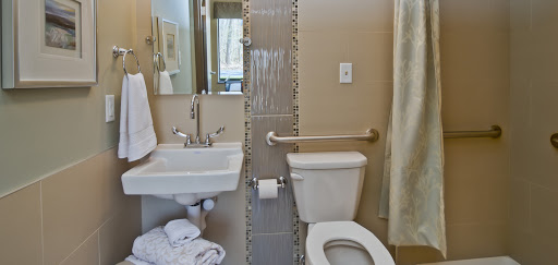 A compact bathroom featuring essential fixtures including a toilet, sink, and shower area.