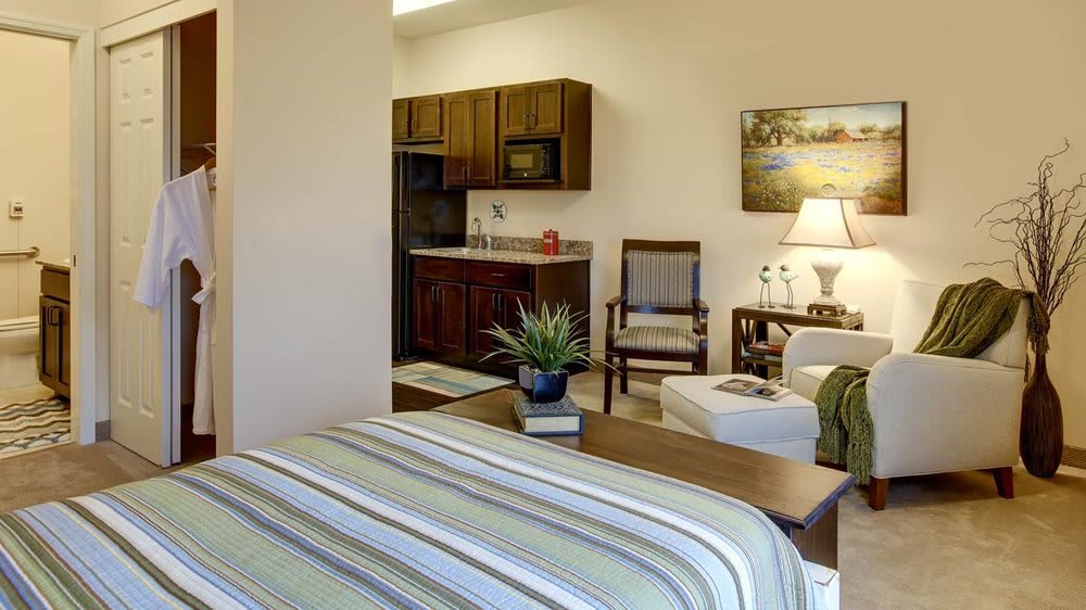 Cozy studio apartment featuring a kitchenette and comfortable furnishings.