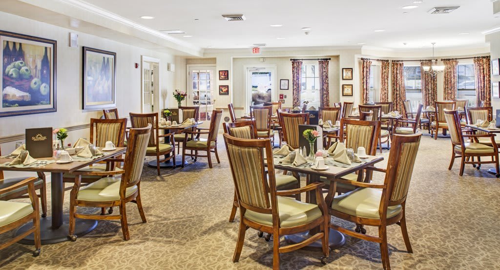 An elegantly arranged dining area with neatly set tables and comfortable chairs.
