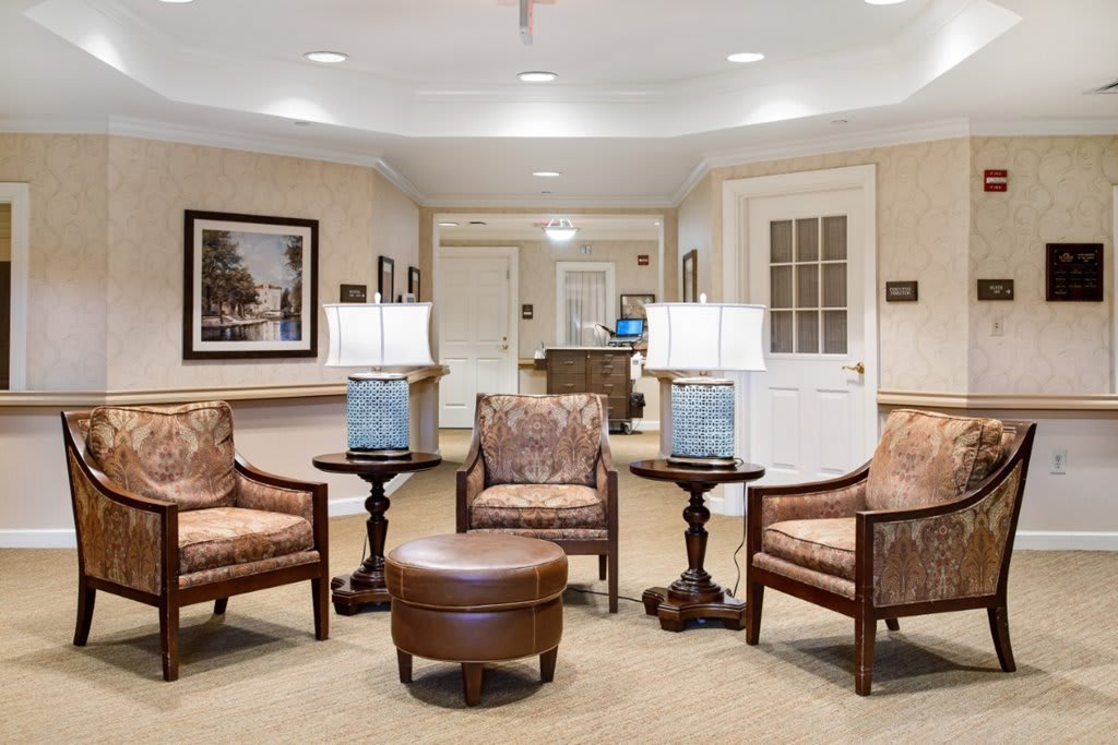 A cozy lobby area with comfortable chairs, tables, and lamps creating a welcoming atmosphere.