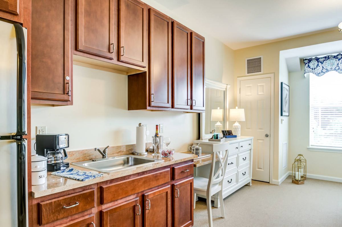 A cozy kitchen area with wooden cabinets and a desk space.