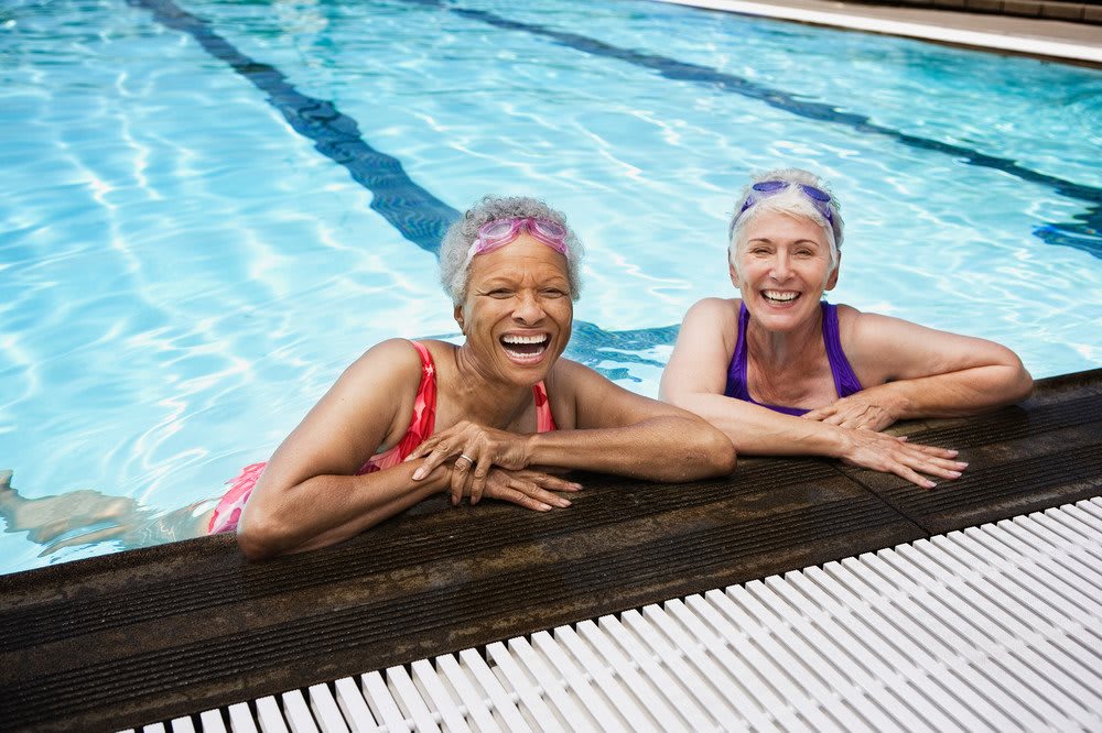 Two senior women enjoying their time in the swimming pool.