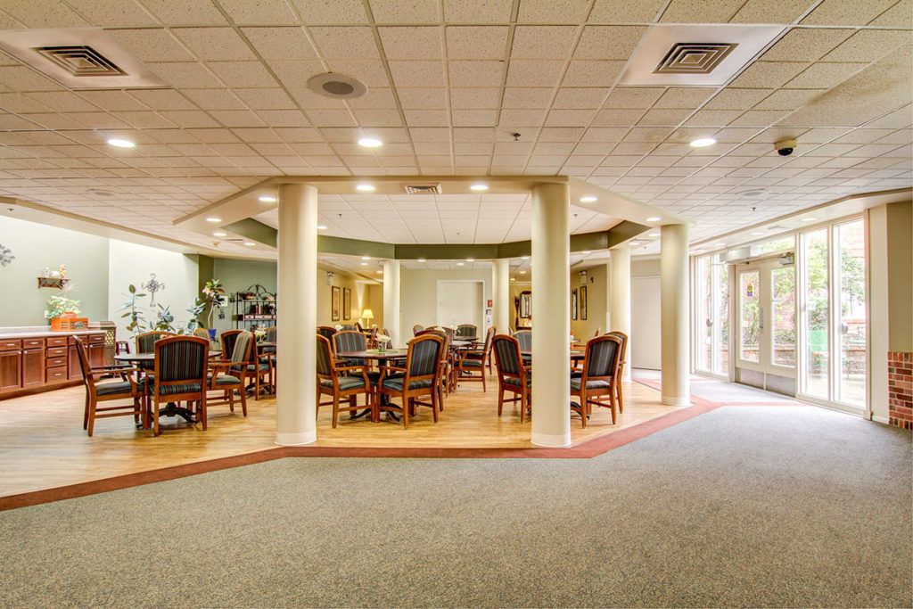 A well-lit dining area with several wooden tables and chairs arranged for guests.