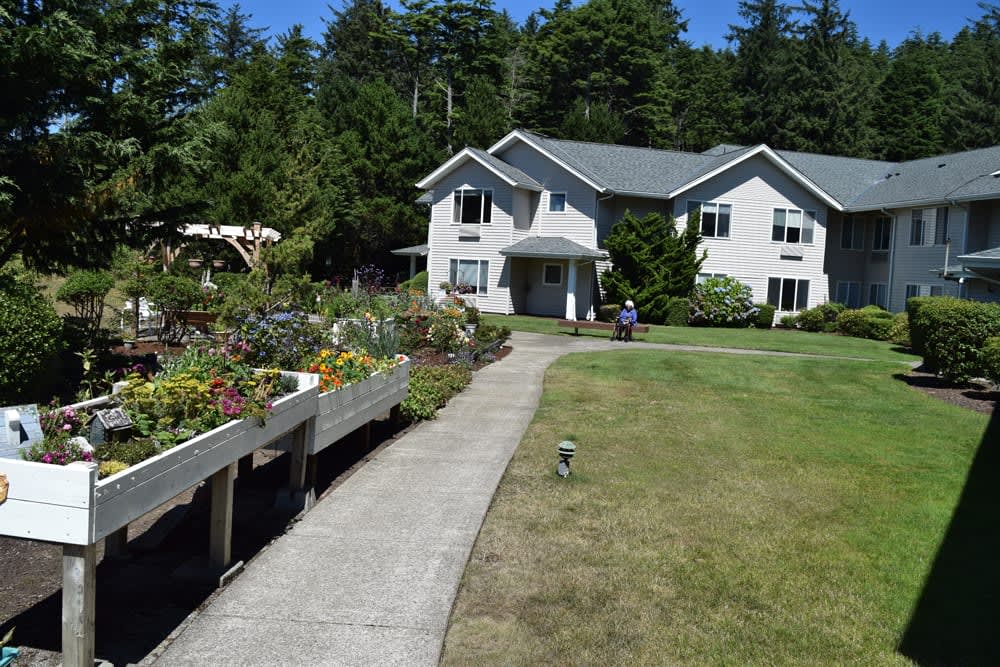 A charming house with a garden pathway surrounded by trees.