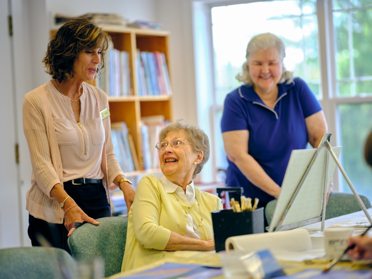 A group of women enjoying a conversation in an office setting.