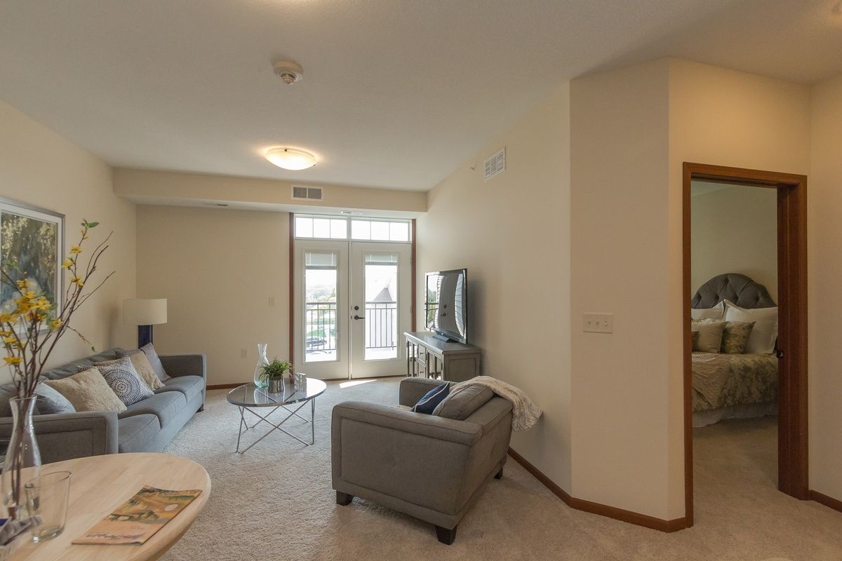 A modern living room with a sofa, TV, and large windows.