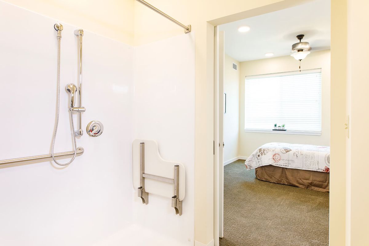 Accessible bathroom with a view into a bedroom.