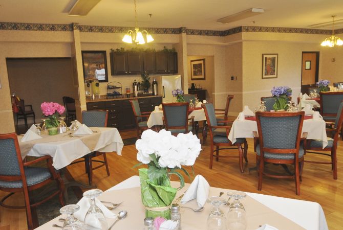 A cozy dining room with neatly arranged tables and floral decorations.