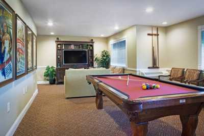 A cozy game room featuring a pool table and a large television.