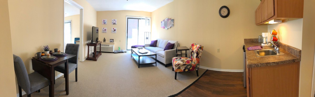 A cozy living room featuring a sofa, coffee table, and colorful accent chair.