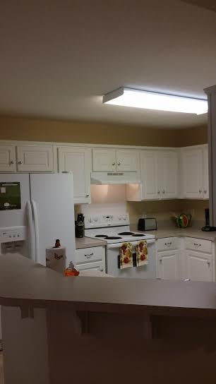 A modern kitchen with white cabinets and appliances.