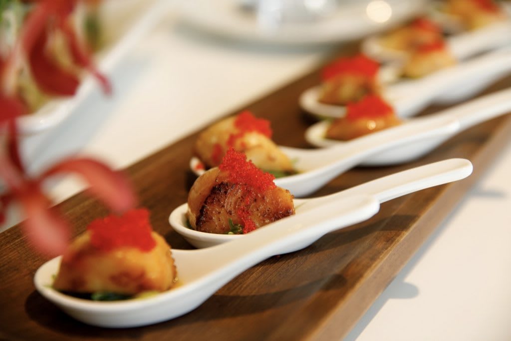 Gourmet appetizers elegantly presented on individual spoons.