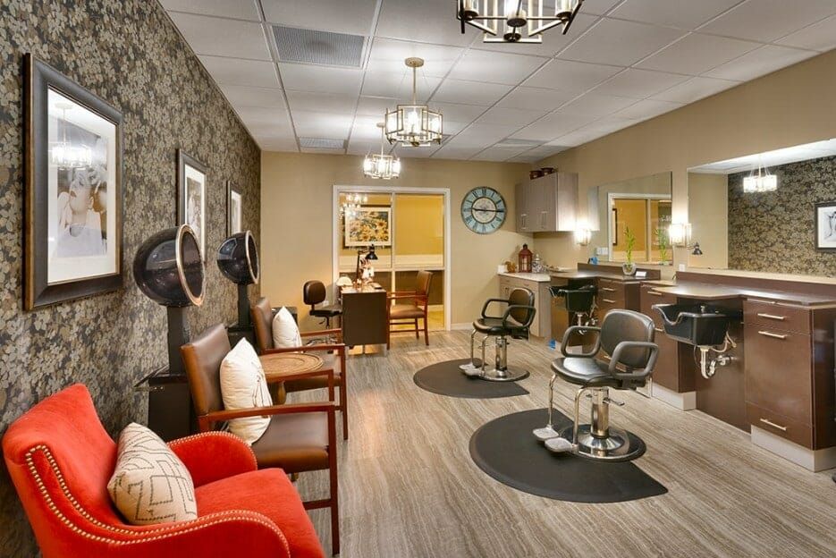 A cozy and stylish salon interior with comfortable chairs, mirrors, and hairdryers.