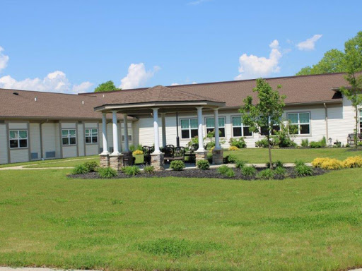 A well-maintained building surrounded by lush green grass and landscaped gardens on a clear day.