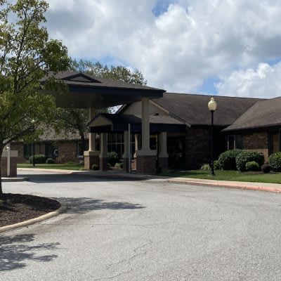 The exterior view of a building with a prominent entrance under a cloudy sky.