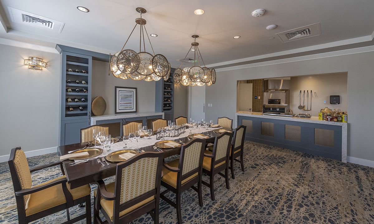 A beautifully decorated dining room with an elegant table setting and modern chandeliers.