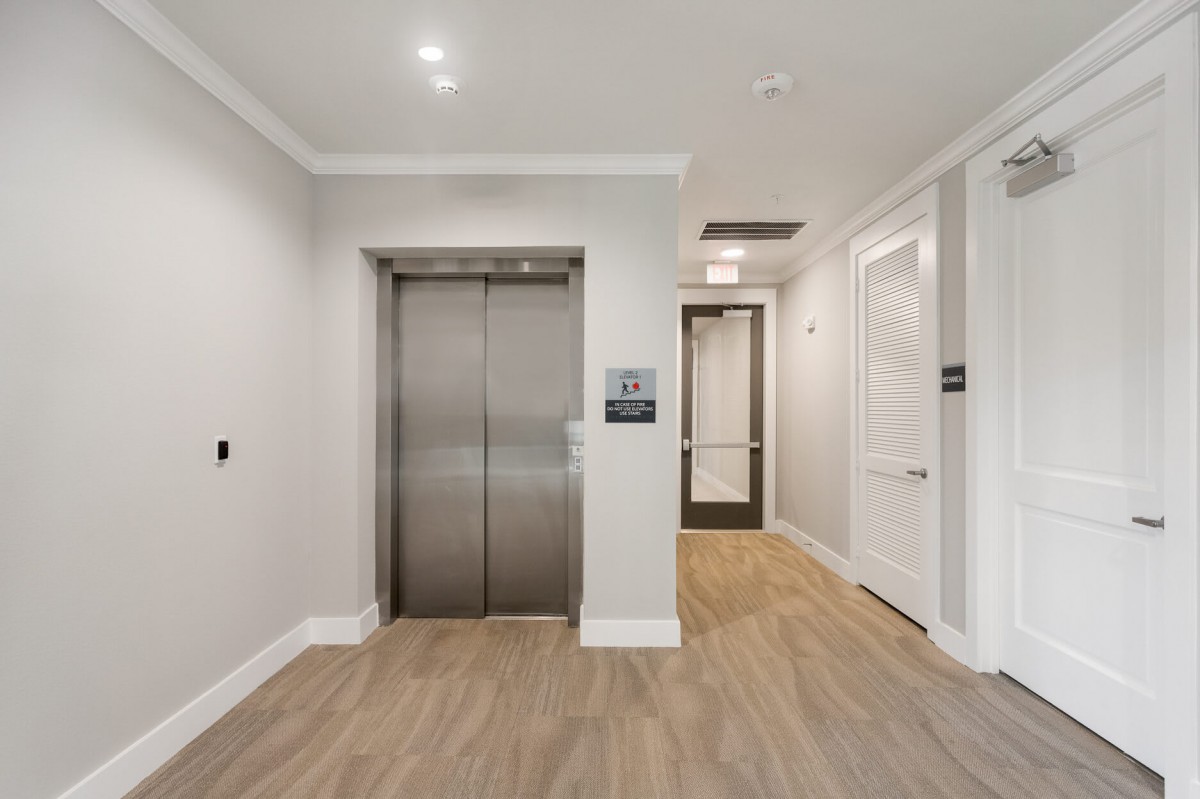Modern hallway with an elevator and sleek interior design.