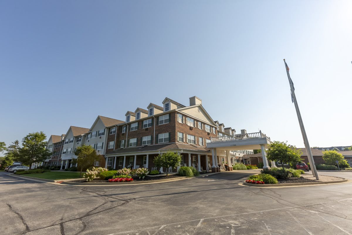 A large hotel building with a landscaped exterior and a clear blue sky.