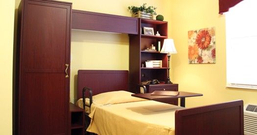A cozy bedroom with a single bed and built-in shelving.