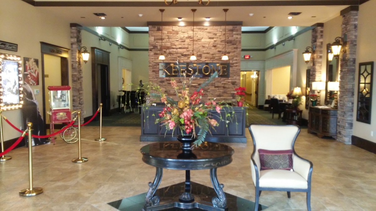 A hotel lobby area featuring a central table with a floral arrangement.
