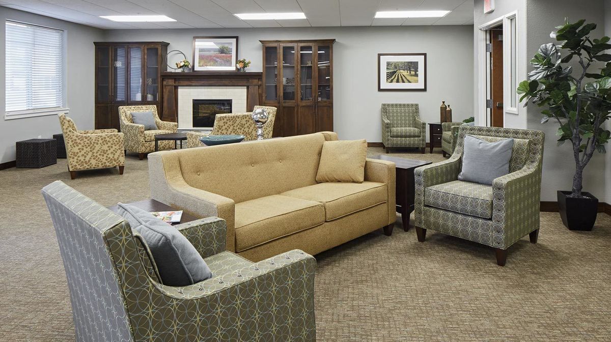 A cozy living room with a sofa, armchairs, and a fireplace.