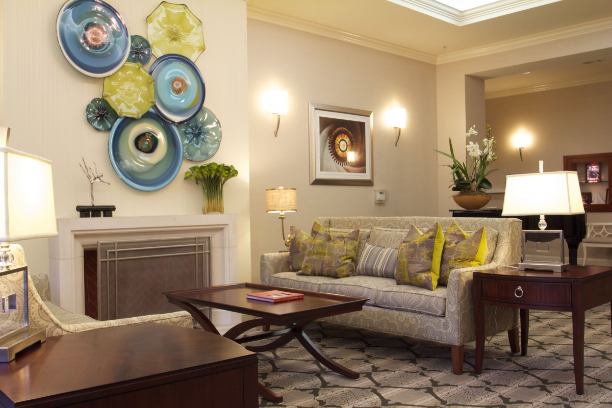 A cozy and elegantly designed living room featuring a sofa, decorative plates on the wall, and ambient lighting.