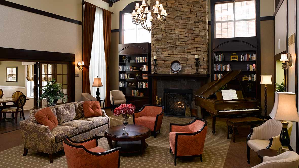 A luxurious living room with a cozy fireplace, elegant chandelier, and stylish furniture.