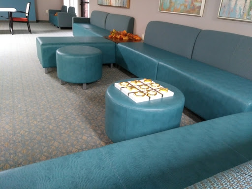 A modern living room setup featuring teal seating and ottomans.