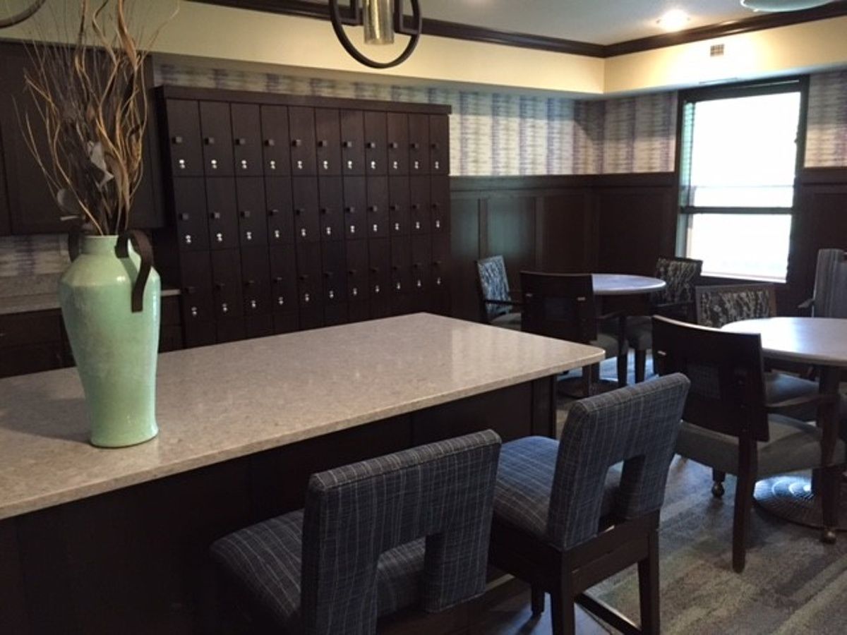 A modern interior space featuring tables, chairs, and lockers.