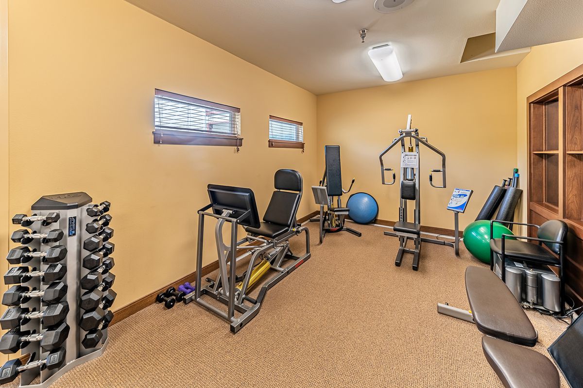 A home gym equipped with various exercise machines and dumbbells.