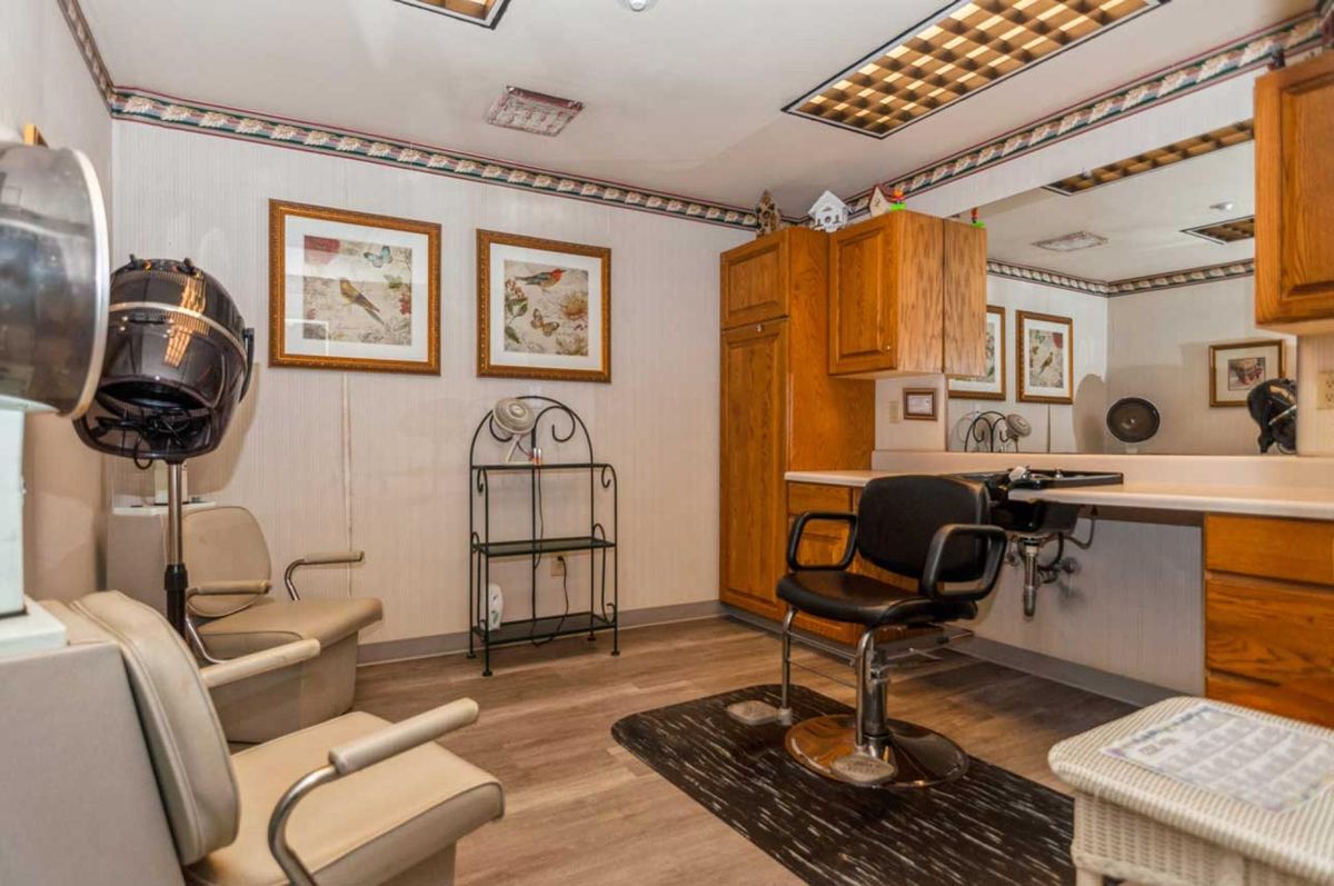 A cozy salon interior featuring a barber chair, mirror, and stylish decor.