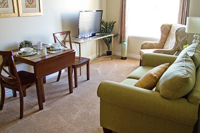 A cozy living room with a sofa, TV, and dining area.