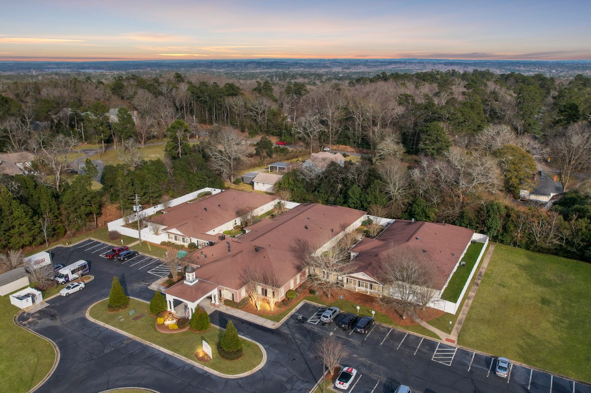 Aerial view of a suburban building complex surrounded by trees.