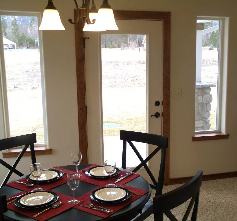 A cozy dining area with a neatly set table for four, featuring elegant place settings and a warm ambiance.