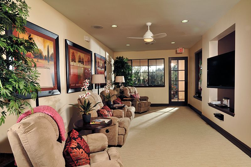 A cozy living room with comfortable seating and decorative paintings on the walls.