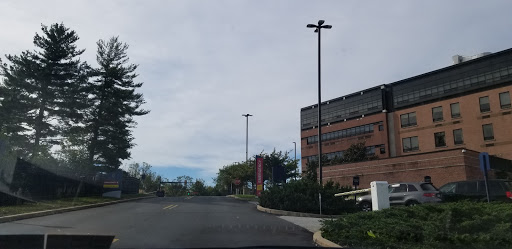 A view of a road leading up to a building under a cloudy sky.