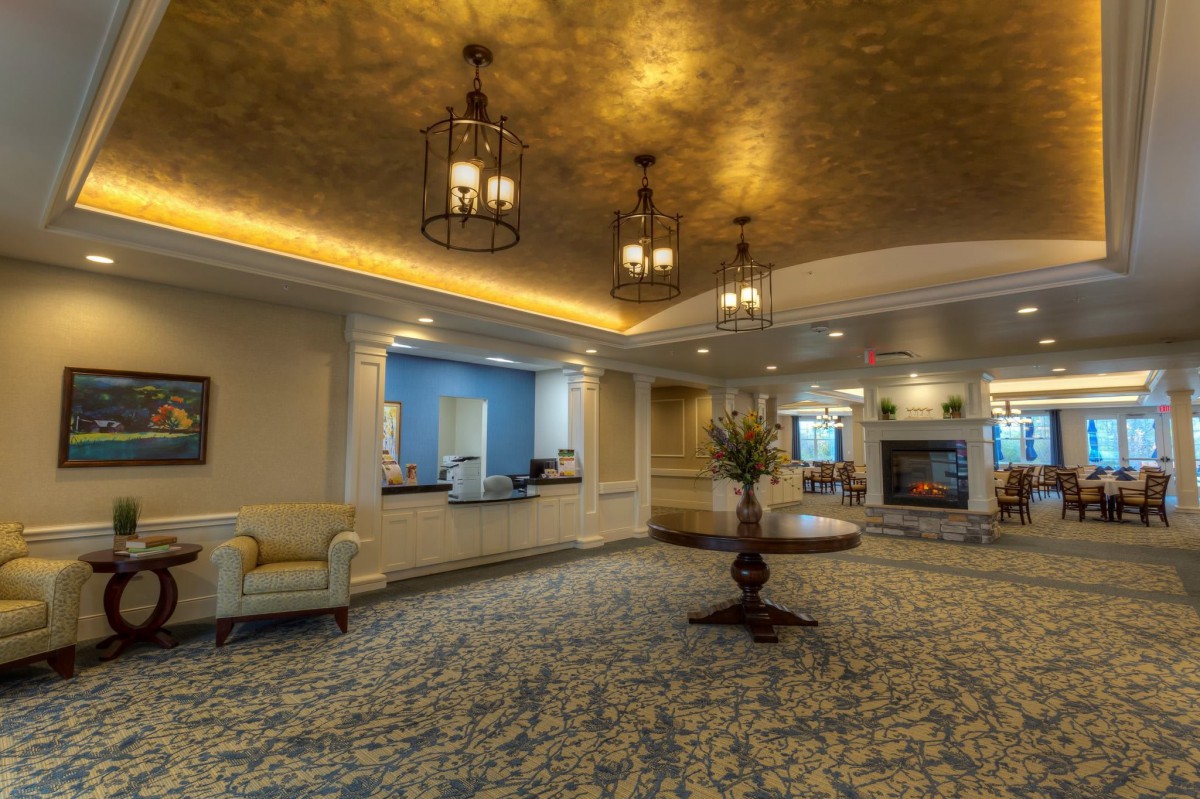 A luxurious lobby featuring elegant chandeliers, a reception desk, and stylish furniture.