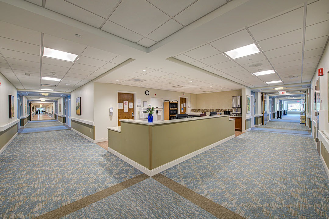 A hospital reception area with a central desk and adjacent corridors.