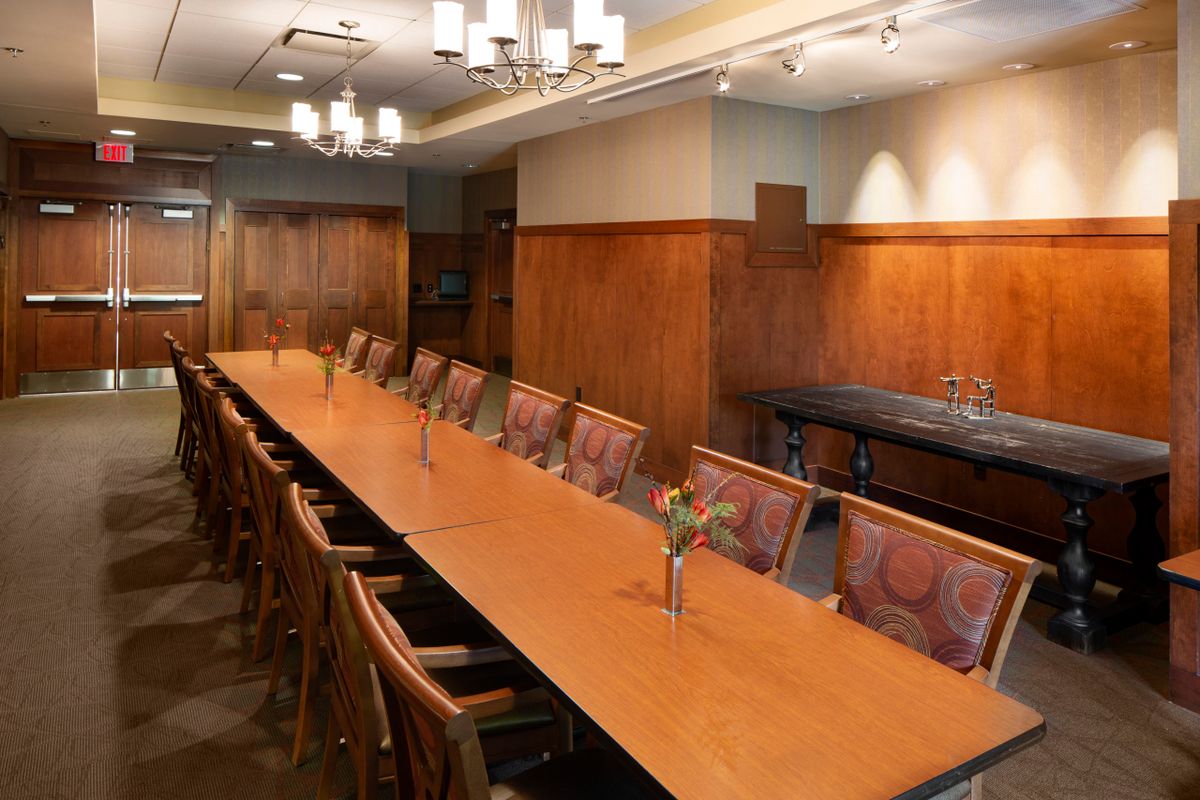 A well-appointed conference room with a long table and comfortable chairs ready for a meeting.