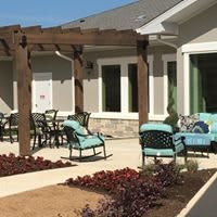 A cozy outdoor patio area with comfortable seating and a wooden pergola.